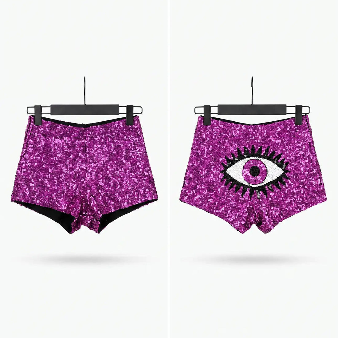 Two pairs of high-waisted, sparkly magenta-purple sequin shorts displayed side by side on black hangers against a light gray background. The left pair has a solid sequin texture, and the right pair features a large black and white eye graphic on the front.